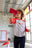 Perpète Tee-shirt Génération rouge pastèque et gris chiné en coton bio porté par Elysa qui joue aux avions en papier. Elle porte également le jean Super Costaud en armalith. 
