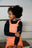 Robe Perpète Power enfant, en coton bio, coloris corail, bretelles réglables par boutons, portée par Emma, vue de face