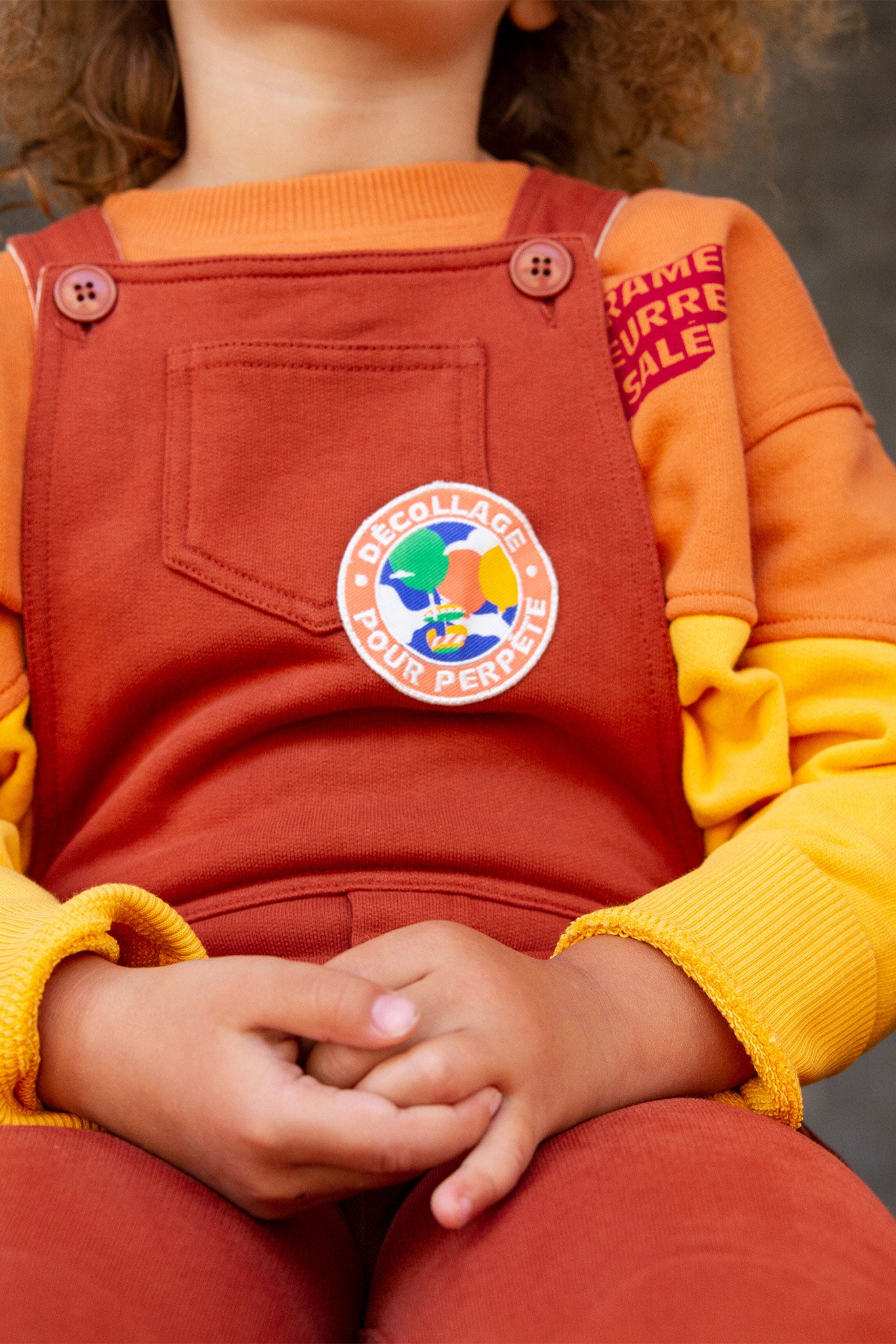 Perpète zoom sur la salopette en molleton coloris chocolat avec écrit décollage pour Perpète. Zoom également sur le sweat Bigoût caramel beurre salé. 