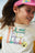 Zoom sur le tee-shirt Future porté par Line en look rétro.