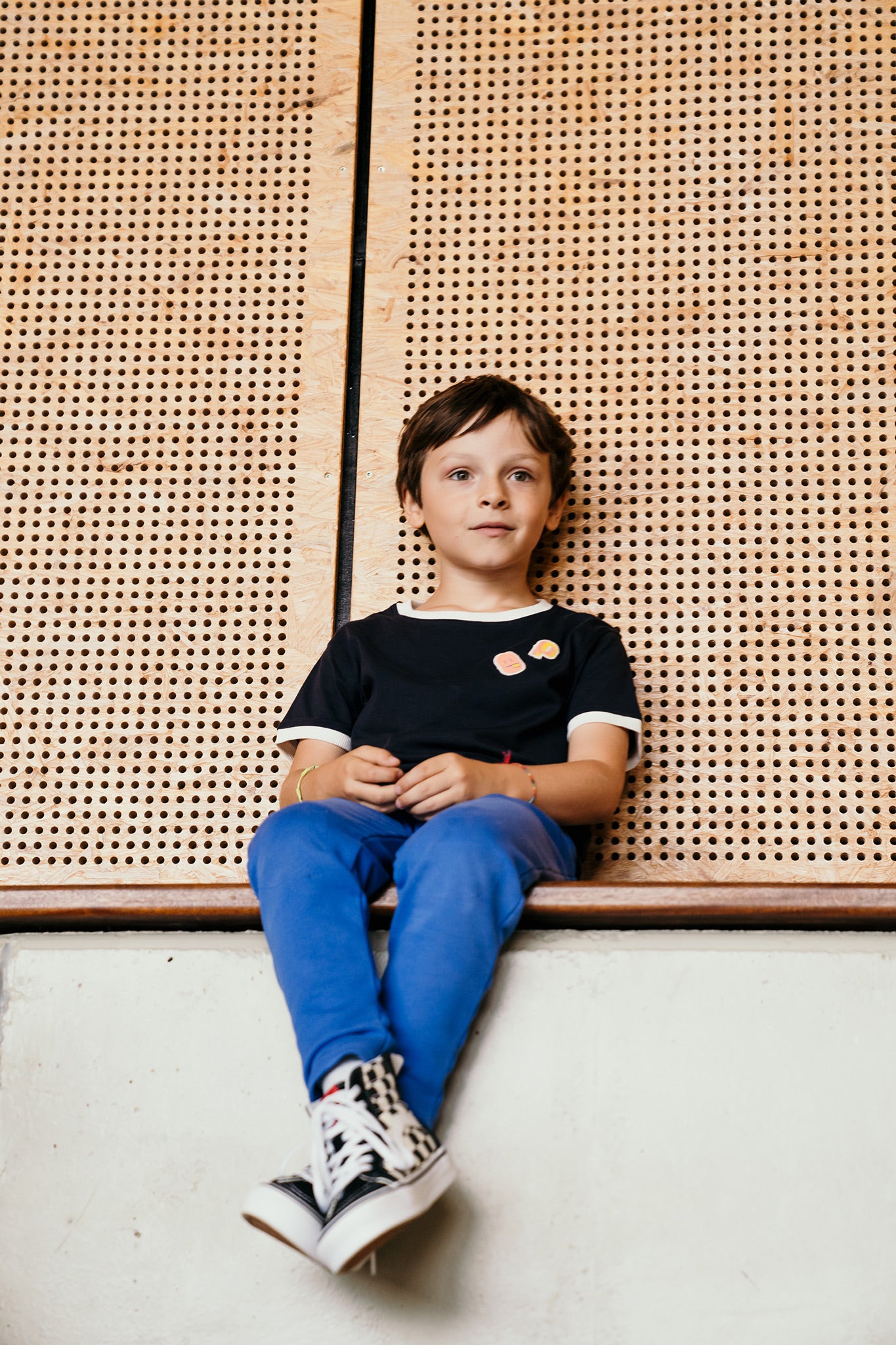 Tee-shirt More Perpète enfant, mixte, coloris marine, à plat, avec le col et les bas de manches contrastés coloris crème, et des patchs smiley sur la poitrine, porté par Gabin, vu de face