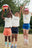 Trois enfants portent le short simply en différentes couleurs, ils jouent au ballon sur la plage.
